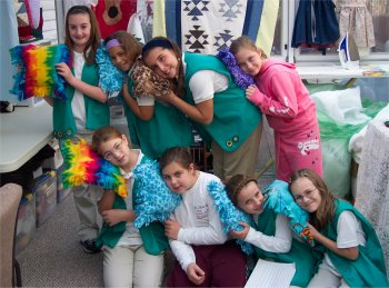 a group of girl scouts showing their projects they sewed for their sewing badge.