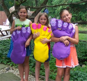 little girls holding a giant foot pillow with toe nails that they sewed