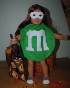 american girl doll in a green m&m halloween costume handmade with a white face mask