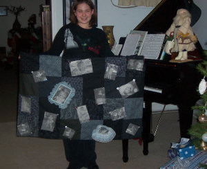 girl holding a black and white memory quilt she made