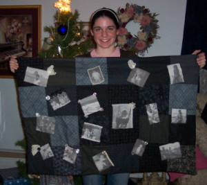 girl holding a memory black and white quilt she made
